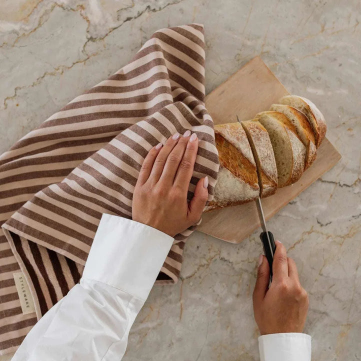 Choc Malt striped Between The Lines Tea Towel drying bread on marble countertop
