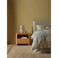 GlobeWest Bower Frame Butter wool rug in modern bedroom with wooden nightstand and neutral bedding