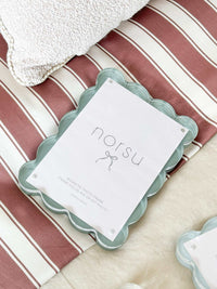 norsu Studio Scalloped Magnetic Photo Frame in sage with scalloped edges and magnetic closure on striped fabric background