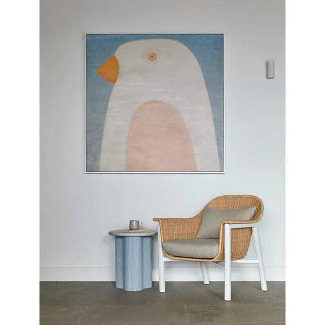 Powder blue Artie Wave Ripple side table with abstract ripple timber veneer base and Carrara marble top next to rattan armchair in modern room