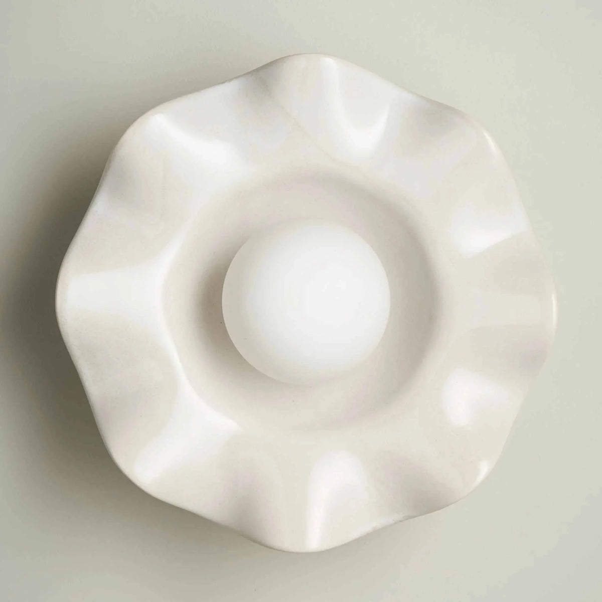 Robert Gordon Pearl Wall Sconce in white crafted clay with wavy design and central globe light