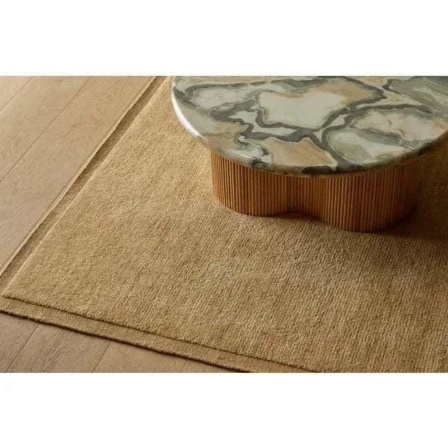 GlobeWest Bower Frame Rug in butter color, hand woven wool area rug beneath marble top wooden coffee table on wooden floor