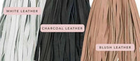 Close-up of Elysian Bouclé Ottoman piping leather options in white, charcoal, and blush colors for customization