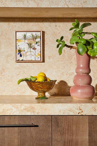 Limited edition fine art canvas print by Georgie Wilson titled Duniper in floating oak frame displayed on a stone shelf with decorative vase and bowl.