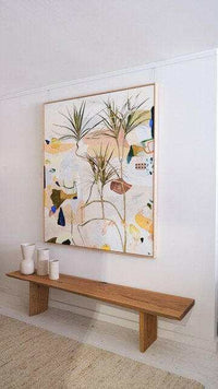 Limited edition fine art canvas print "Duniper" by Georgie Wilson with abstract botanical design in floating oak frame above minimalist wooden bench