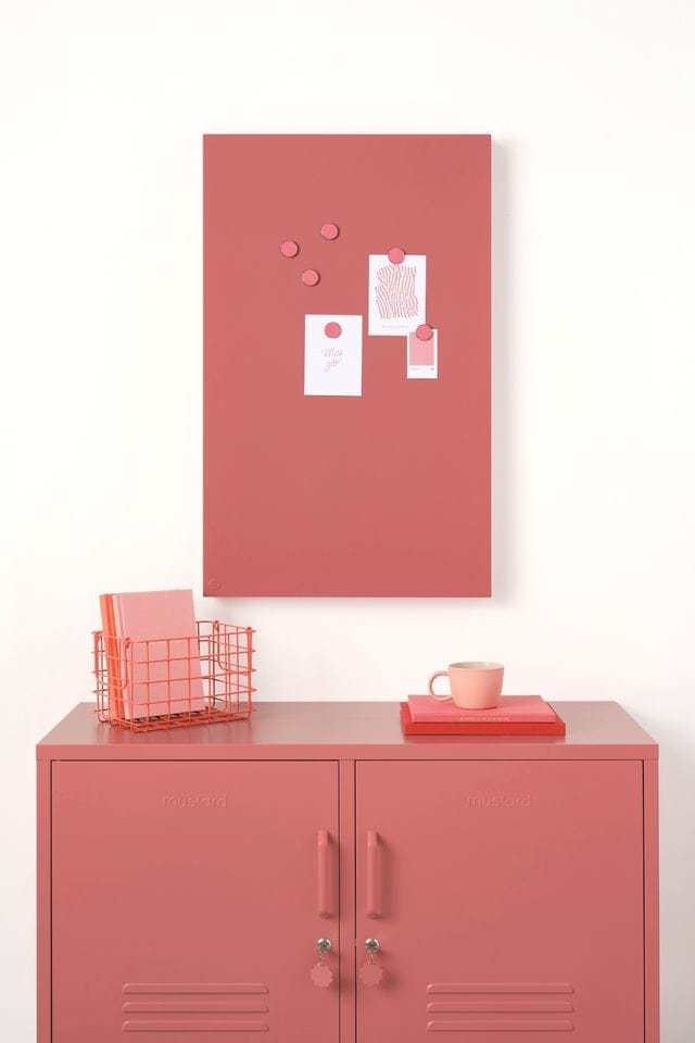 Berry-colored magnetic story board with powder coated finish mounted on wall above matching storage cabinet