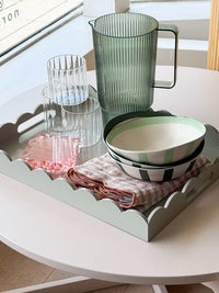 norsu STUDIO rectangular scalloped tray in sage with glass pitcher, bowls, and cloth napkin on white table