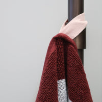 The norsu STUDIO Blue & Burgundy Stripe towel hanging from a bathroom hook