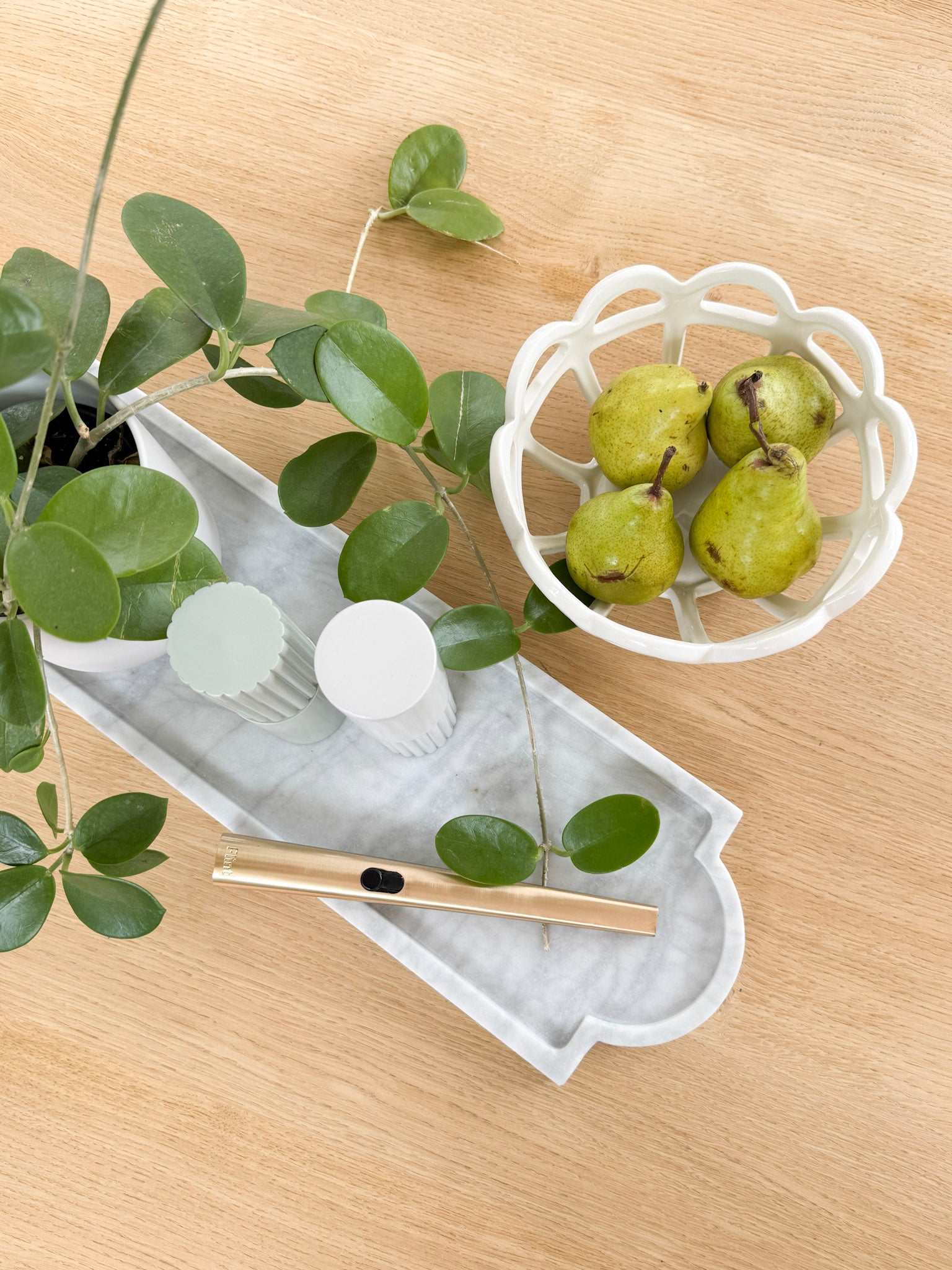 norsu STUDIO Marble Long Tray in white Calacatta marble with natural grey veining on wooden surface with green leaves and pears