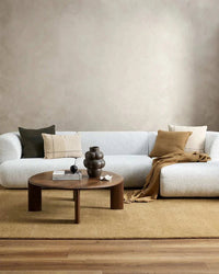 Baya Flaxmill Cushion in fenugreek color on white sofa with neutral decor and wooden coffee table