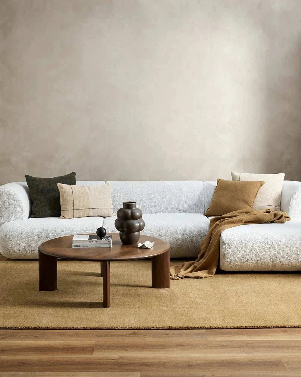 Baya Flaxmill Cushion in fenugreek color on white sofa with neutral decor and wooden coffee table