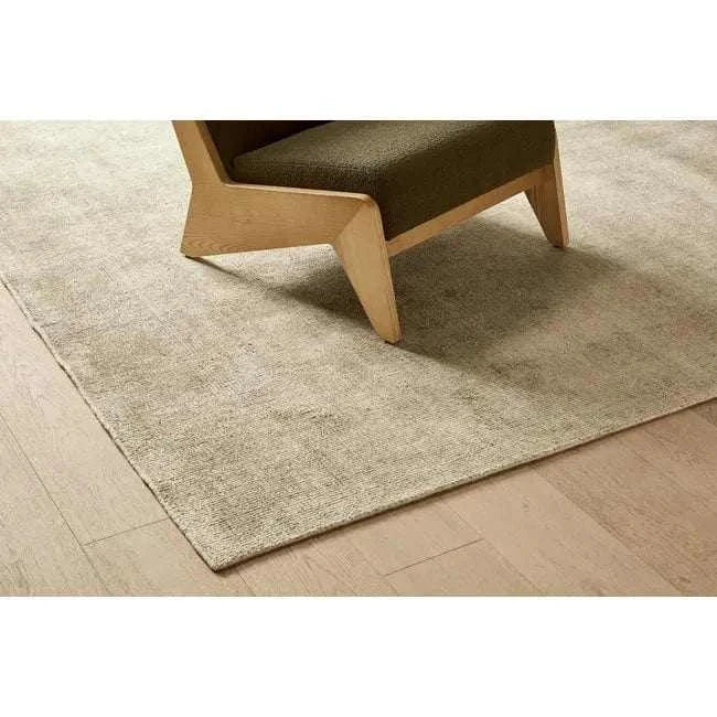 GlobeWest Tepih Neptune Rug in silver grey hand-woven wool blend on wooden floor under chair