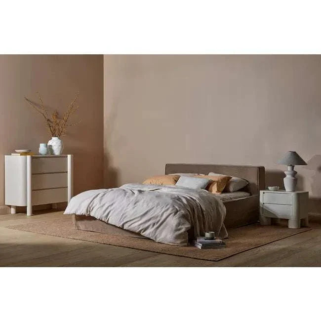 GlobeWest Artie Dresser in powder blue with pillar legs and rounded fronts beside a modern bed in neutral bedroom setting