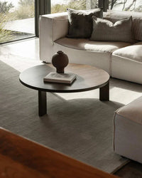 Baya Haywood Floor Rug in Slate under round wooden coffee table with neutral-toned sofa in modern living room