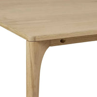 Close-up of Globe West Huxley Curve Dining Table corner with oak veneer top and solid oak leg in natural oak finish