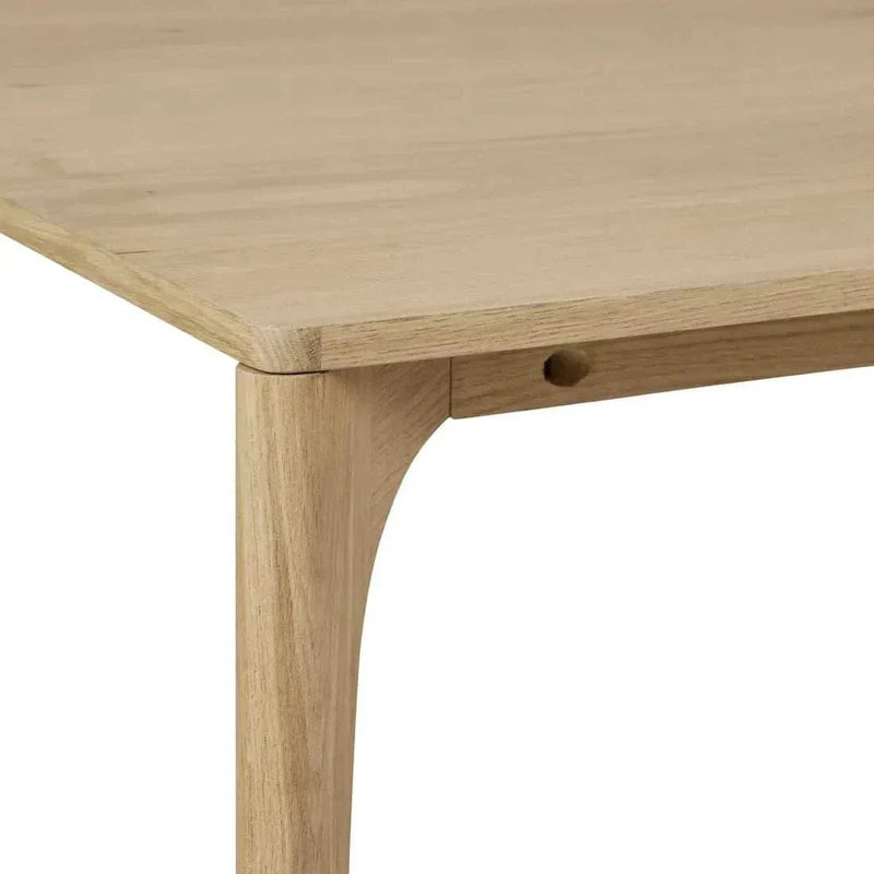 Close-up of Globe West Huxley Curve Dining Table corner with oak veneer top and solid oak leg in natural oak finish