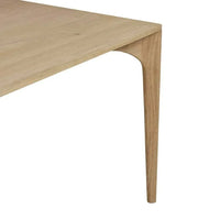 Close-up of the Globe West Huxley Curve Dining Table corner featuring natural oak veneer top and curved solid oak leg.