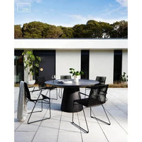 Globe West Livorno round dining table with grey speckle finish, outdoor patio setting with black mesh chairs