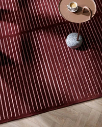 Baya Marlow Floor Rug in wine color with burgundy and pale pink stripes, hand-tufted 100% New Zealand wool texture.