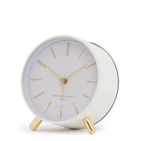 Maya Silent Alarm Clock in white with gold numerals, hands, and feet, featuring silent sweep movement and built-in nightlight.