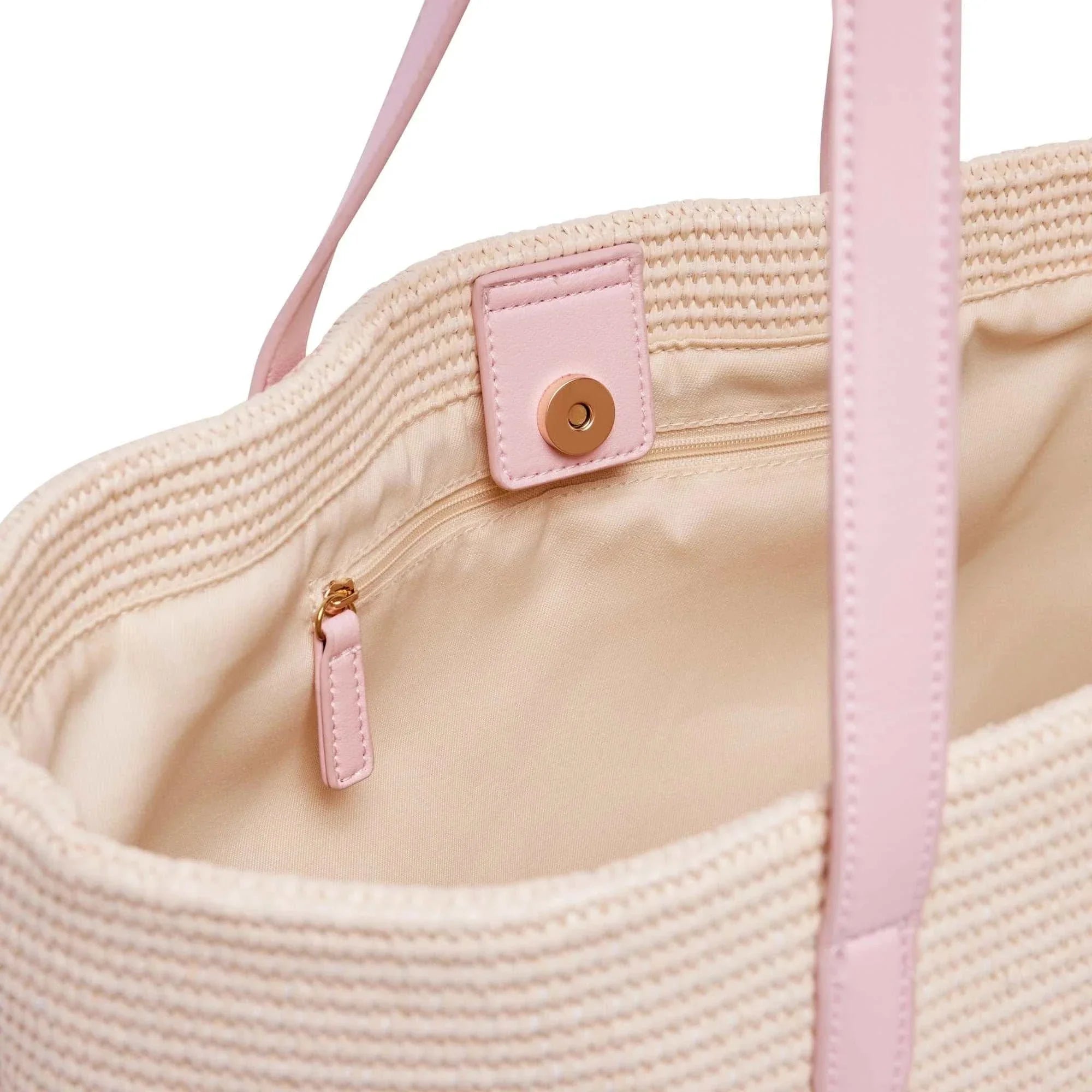 Interior close-up of Base Supply Panier bag in pink with woven straw, cotton lining, zipped pocket, and magnetic closure