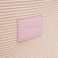 Close-up of pink Base Supply Panier woven straw bag label on textured surface