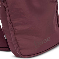 Close-up of burgundy Base Supply Bottle Sling made from soft crinkle waterproof fabric with adjustable strap and front pocket