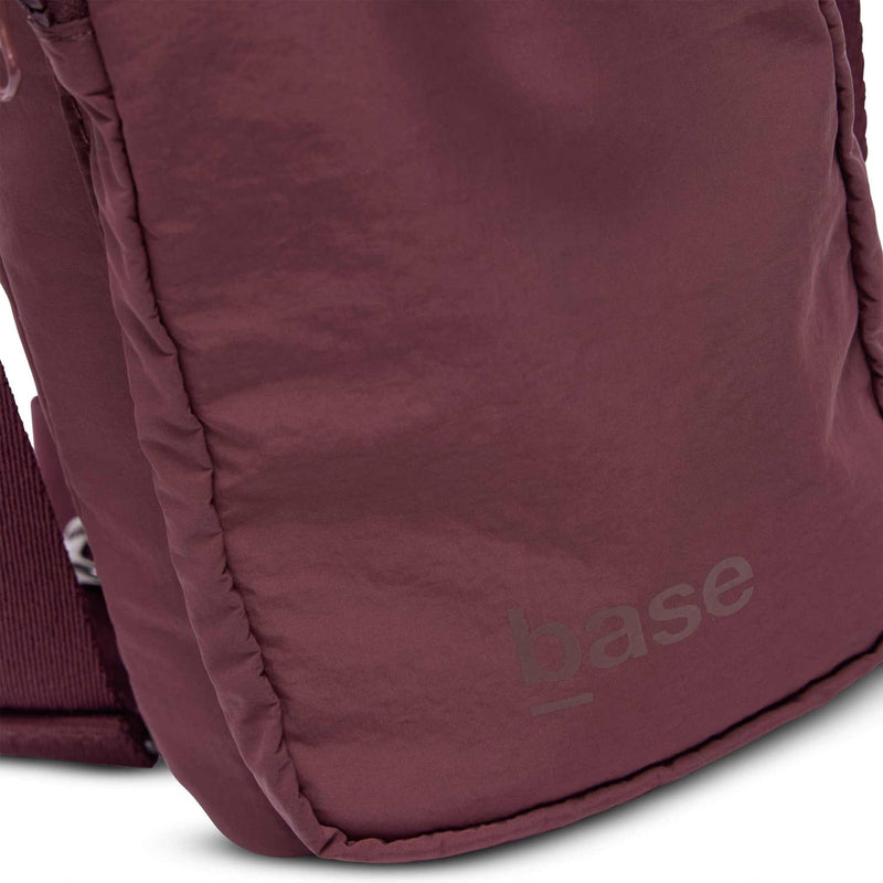 Close-up of burgundy Base Supply Bottle Sling made from soft crinkle waterproof fabric with adjustable strap and front pocket