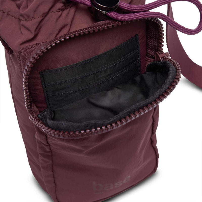 Base Supply Bottle Sling crossbody bag in burgundy with waterproof soft fabric and zippered pocket.