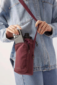 burgundy Base Supply Bottle Sling crossbody bag with adjustable strap holding water bottle and phone