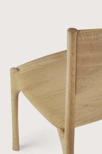 Close-up view of Ethnicraft PI Dining Chair made from natural oak with sleek, curved design and polished imperfect finish