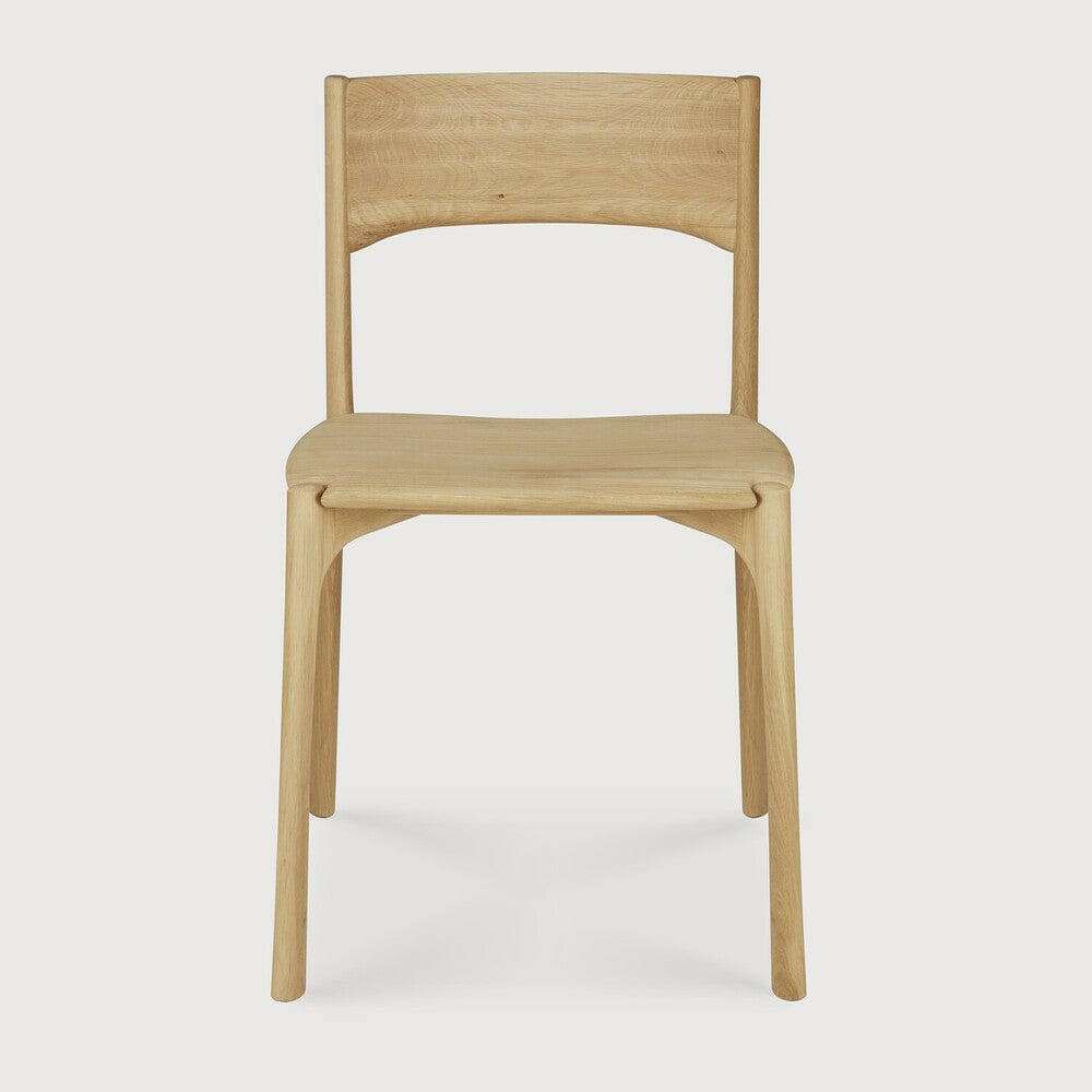 Ethnicraft PI Dining Chair in natural oak with sleek, handcrafted wooden design and curved backrest.