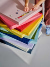 Colorful stack of Mustard Made story boards with magnetic surfaces and powder coated finishes in various pastel and bright shades