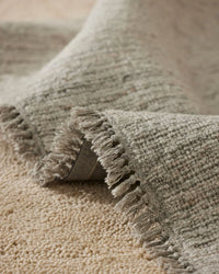Puglia Rug Fox chunky woven textured rug with ivory and grey tones and fringe detail in living room setting