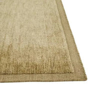 Close-up of the GlobeWest Bower Frame Rug in moss green, hand-woven 100% wool with a simple bordered design.