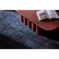 GlobeWest Tepih Neptune Rug Midnight hand-woven wool blend indoor area rug beneath reddish-brown coffee table with open book