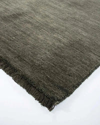 Close-up of the Sandringham Floor Rug in forest green with handknotted wool pile and fringed edges.