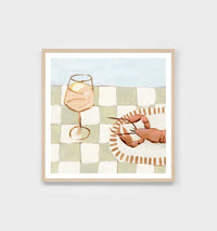 Middle of Nowhere seaside dining print featuring a glass with a lemon slice and a lobster on a checkered tablecloth in sage tones with a wooden frame