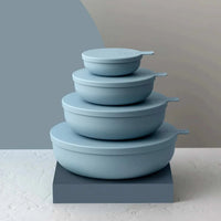 Sky blue Styleware nesting bowls set with snap-tight lids stacked on a grey pedestal