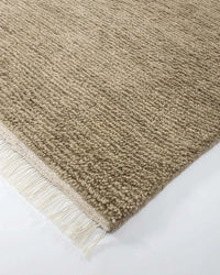 Close-up of Baya Tanami Floor Rug in fossil taupe with hand-knotted ribbed texture and soft cotton fringe