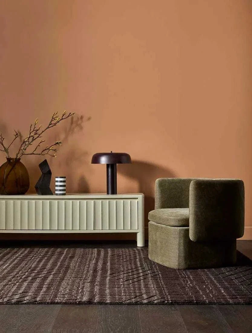 Modern Globe West Canopy Table Lamp in burgundy metal on cream sideboard with decorative items in stylish living room setting