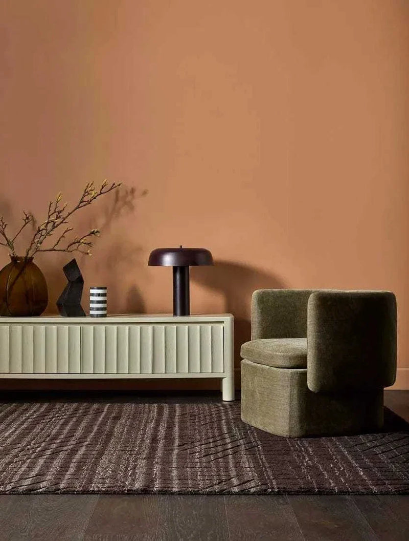 Modern Globe West Canopy Table Lamp in burgundy metal on cream sideboard with decorative items in stylish living room setting