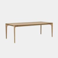 Globe West Huxley Curve Dining Table in natural oak with curved solid oak legs and veneer top