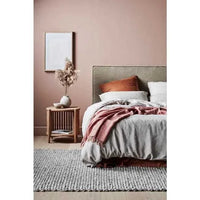 GlobeWest Tepih Bobble Rug in fog color with subtle bobble texture, hand-woven wool blend, styled in a cozy bedroom setting