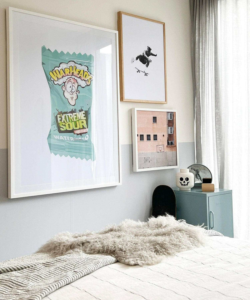Dom Gauci Kids Art Print Sour Power framed on bedroom wall above bed with cozy faux fur throw and skateboard decor
