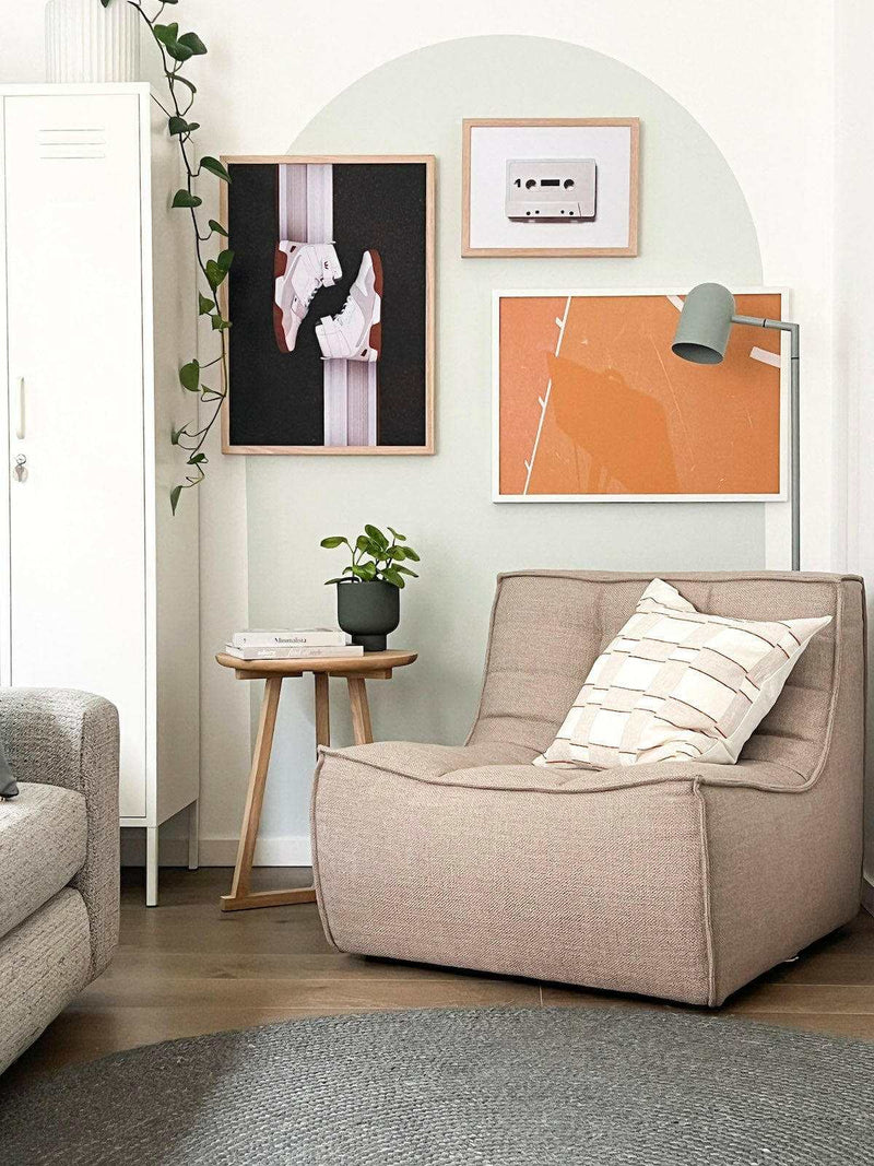 Modern living room with beige armchair, decorative pillow, side table with plant, and Court Lines Print wall art in various sizes and frames