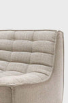 Close-up of Ethnicraft Sofa N701 in dark beige fabric with cushioned, tufted upholstery and curved edges.
