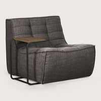 Dark grey Ethnicraft Sofa N701 single-seater with tufted upholstery and attached black metal side table.