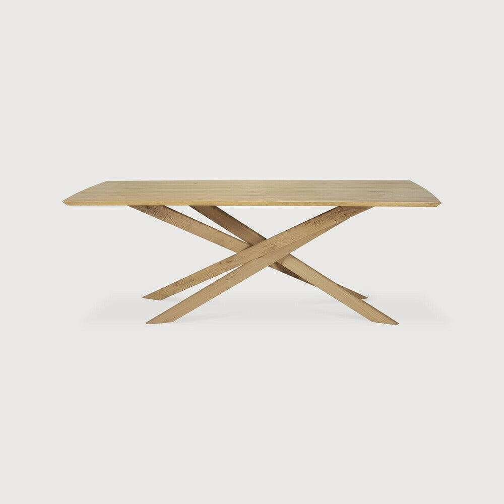 Natural oak Ethnicraft Mikado dining table with sculptural crossed legs and solid European oak top