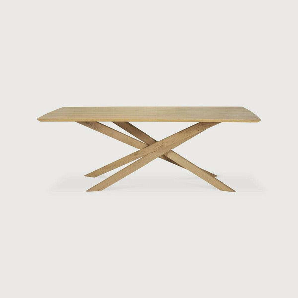 Natural oak Ethnicraft Mikado dining table with sculptural crossed legs and solid European oak top